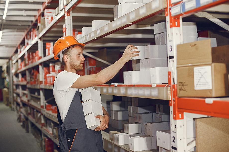 Male staff worker picking up the parts from shelf